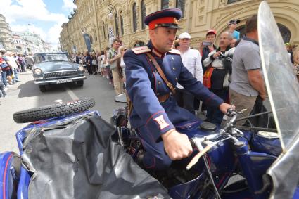 Москва. Участник  ГУМ-авторалли Gorkyclassic-2017  в форме милиционера 50-х годов перед стартом гонки .