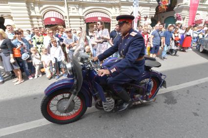 Москва. Участник  ГУМ-авторалли Gorkyclassic-2017  в форме милиционера 50-х годов перед стартом гонки .