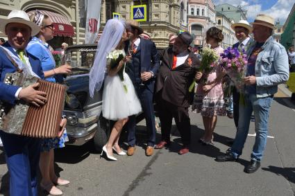 Москва.  Председатель наблюдательного совета  Bosco di Ciliegi Group Михаил Куснирович ( в центре) со свадебным экипажем  автомобиля `Чайка`перед  стартом  ГУМ-авторалли Gorkyclassic-2017 возле ГУМа.