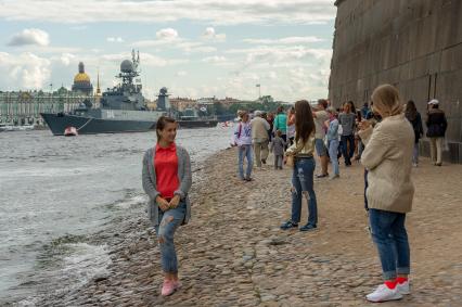 Санкт-Петербург.Туристы фотографируют военные корабли  во время репетиции парада  посвященного Дню ВМФ.