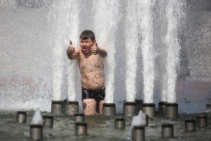 Белоруссия. Минск. Мальчик купается в фонтане.
