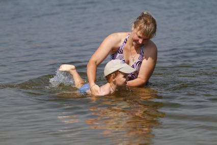 Красноярск. Женщина с ребенком на городском пляже.