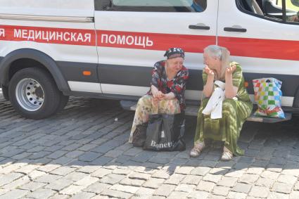 Москва. Пенсионерки сидят около машины скорая медицинская помощь.