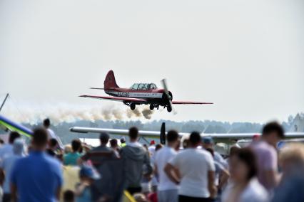 Новосибирская область. Самолет Як-52 пилотажной группы `Открытое небо` в небе во время авиашоу `Взлетай, мой край родной!` на аэродроме Мочище.