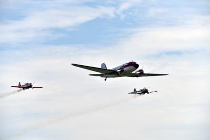 Новосибирская область. Самолеты Douglas DC-3 (в центре) и Як-52 в небе во время авиашоу `Взлетай, мой край родной!` на аэродроме Мочище.