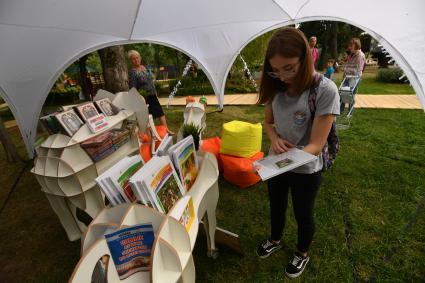 Москва.  Девушка смотрит книги в книжной палатке `Комсомольской правды`.