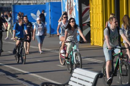 Москва.  Молодые люди  катаются на велосипедах   в парке Горького.