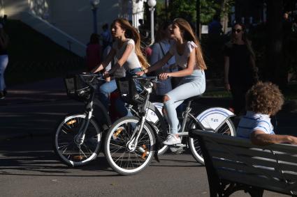 Москва.  Девушки  катаются на велосипедах  в парке Горького.