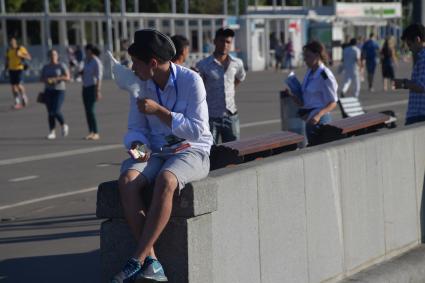 Москва. Молодой человек ест сладкую вату  в парке Горького.