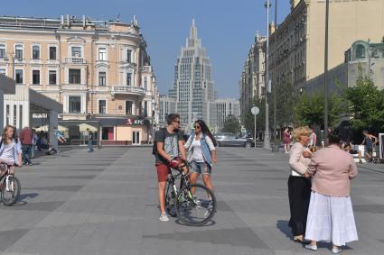 Москва. Велосипедист на Триумфальной площади. На заднем плане - Бизнес-центр `Оружейный`.