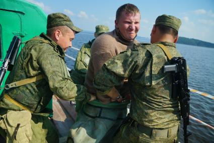 Свердловская область. Военнослужащие помогоют экипироваться водолазу во время тактико-специальных учений соединений железнодорожных войск ЦВО (центральный военный округ) по наведению понтонного моста