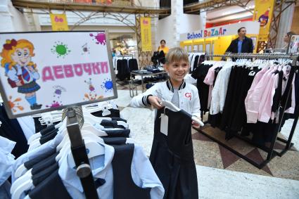 Москва. Девочка выбирает школьную форму  к началу учебного года на школьной ярмарке в `Центральном детском магазине`.