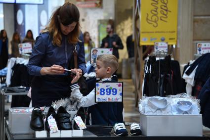 Москва.  Мальчик выбирает школьную форму  к началу учебного года на школьной ярмарке в `Центральном детском магазине`.