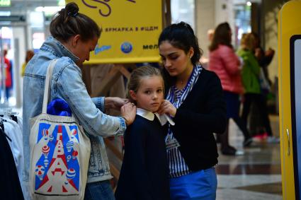 Москва. Девочка примеряет школьную форму  к началу учебного года на школьной ярмарке в `Центральном детском магазине`.