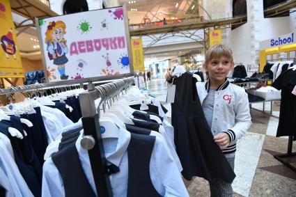 Москва. Девочка выбирает школьную форму  к началу учебного года на школьной ярмарке в `Центральном детском магазине`.