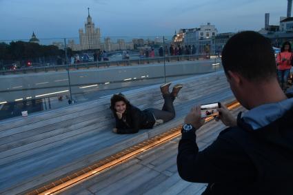 Москва. Девушка фотографируется на `парящем мосту` природно-ландшафтного парка `Зарядье`.