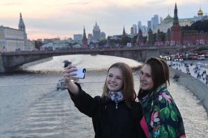 Москва. Девушки фотографируются на `парящем мосту` природно-ландшафтного парка `Зарядье`.