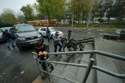 Екатеринбург. Инвалид-колясочник самостоятельно поднимается по ступенькам, из-за слишком крутого пандуса, во время тестирования доступности городской среды для людей с ограниченными возможностями