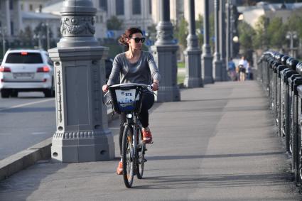 Москва. Девушка едет  на велосипеде по Большому Каменному мосту.