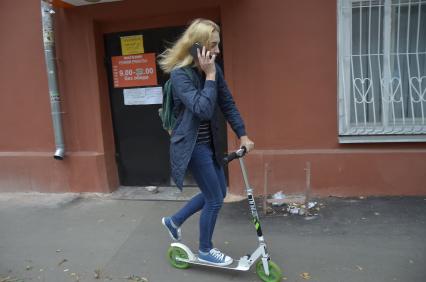 Тула. Девушка на самокате едет по городу.