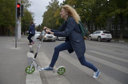 Тула. Девушка на самокате едет по городу.