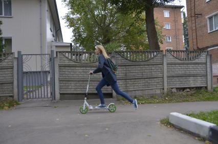 Тула. Девушка на самокате едет по городу.