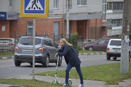 Тула. Девушка на самокате едет по городу.