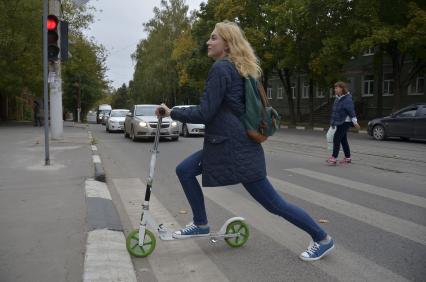 Тула. Девушка на самокате едет по городу.