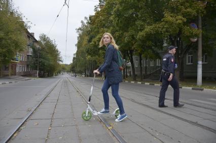 Тула. Девушка на самокате едет по городу.