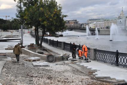 Москва.   Работы по укладке тротуарной  плитки на Якиманской набережной.