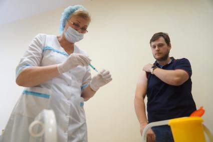 Екатеринбург. Сотрудник городской администрации в медицинском кабинете перед постановкой прививки от гриппа