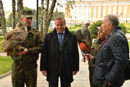 Москва. Кремлевские сокольники Алексей Тюрин с филином Филей, советник директора ФСО России Сергей Девятов, Юлия Карасева с ястребом Альфа и корреспондент `Комсомольской правды` Александр Гамов ( слева направо) на территории Кремля.