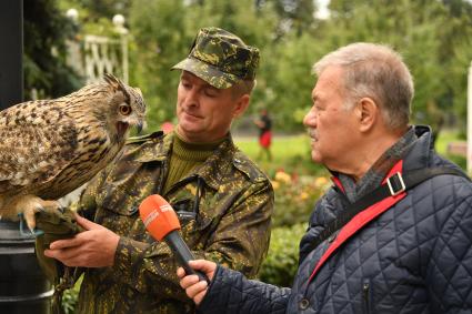 Москва. Корреспондент `Комсомольской правды` Александр Гамов и кремлевский сокольник Алексей Тюрин с филином Филей  на территории  Кремля.