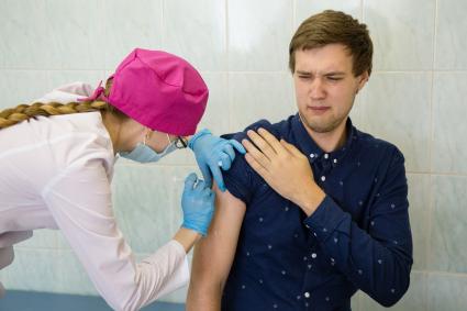 Челябинск. Мужчина в поликлинике делает прививку от гриппа.
