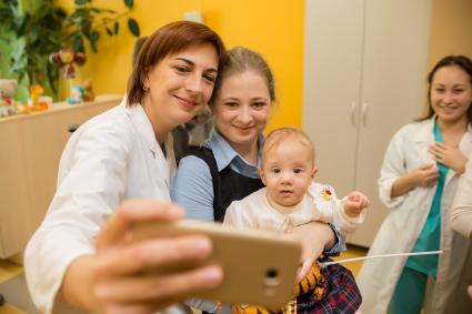 Челябинск. Врач с пациентами делают селфи в  Областном перинатальном центре.