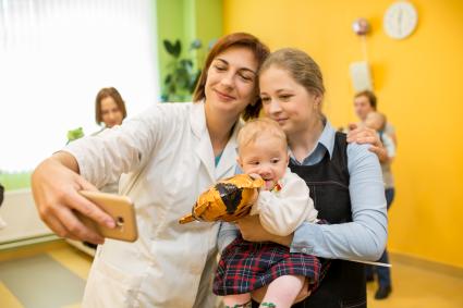 Челябинск. Врач с пациентами делают селфи в  Областном перинатальном центре.