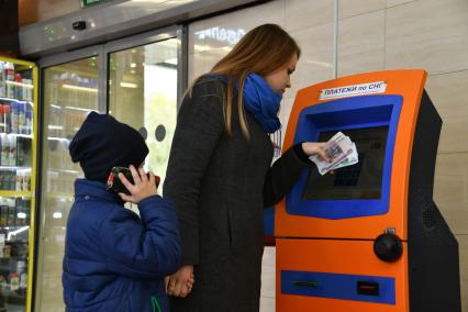 Москва.  Девушка с ребенком оплачивают мобильную связь.