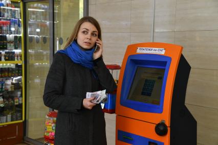 Москва.  Девушка оплачивает мобильную связь.