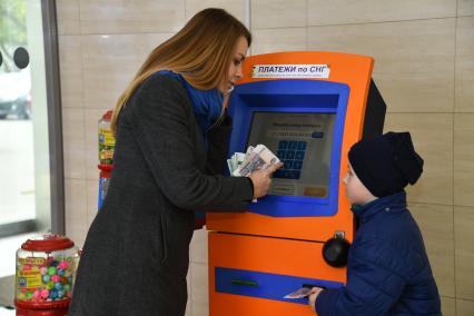 Москва.  Девушка с ребенком оплачивают мобильную связь.