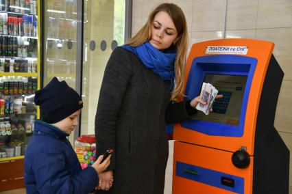 Москва.  Девушка с ребенком оплачивают мобильную связь.