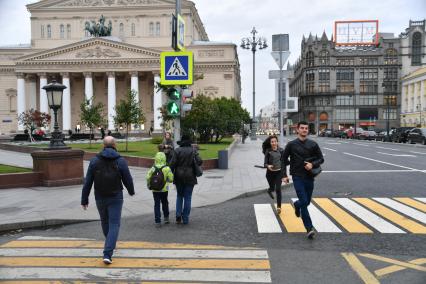 Москва.  Пешеходы  переходят улицу на Театральной площади.