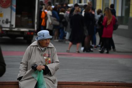 Москва.  Женщина просит милостыню на улице.