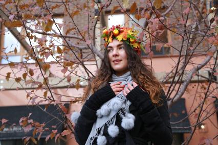 Красноярск. Девушка в венке из осенних листьев гуляет в парке.
