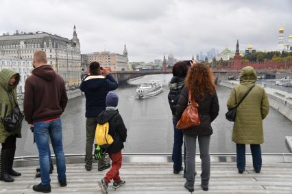 Москва.   Посетители  фотографируют на Парящем мосту ландшафтного парка `Зарядье`.