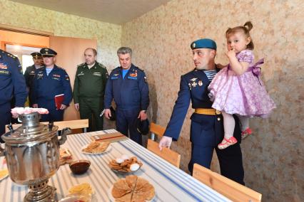 Московская область , Щелково. Главнокомандующий Воздушно-космическими силами, генерал-полковник Виктор Бондарев и заместитель руководителя департамента жилищного обеспечения министерства обороны РФ Анатолий Гринев (слева направо) с семьей военнослужащего осматривают новую квартиру.