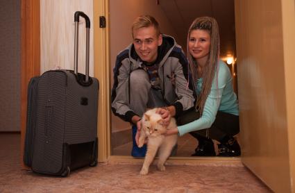 Пермь. Молодой человек с девушкой запускают кошку в свою квартиру в новом доме.
