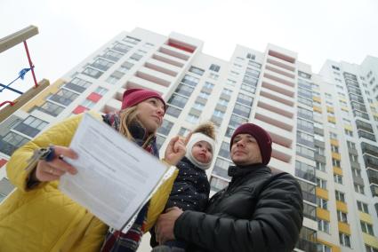 Екатеринбург.  Мужчина и женщина с ребенком   у новостройки.