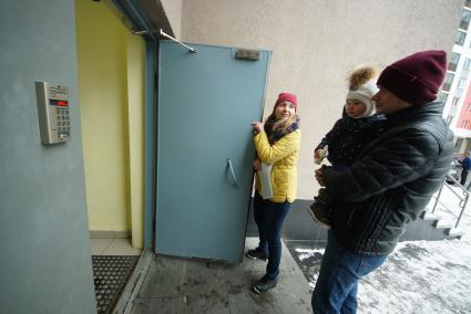 Екатеринбург. Женщина и мужчина с ребенком заходят в подъезд многоэтажного жилого дома.