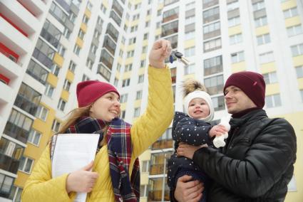 Екатеринбург.  Женщина показывает ключи от квартиры мужчине с ребенком.