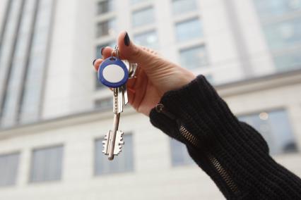 Санкт-Петербург.  Ключи от квартиры на фоне многоэтажного жилого дома.
